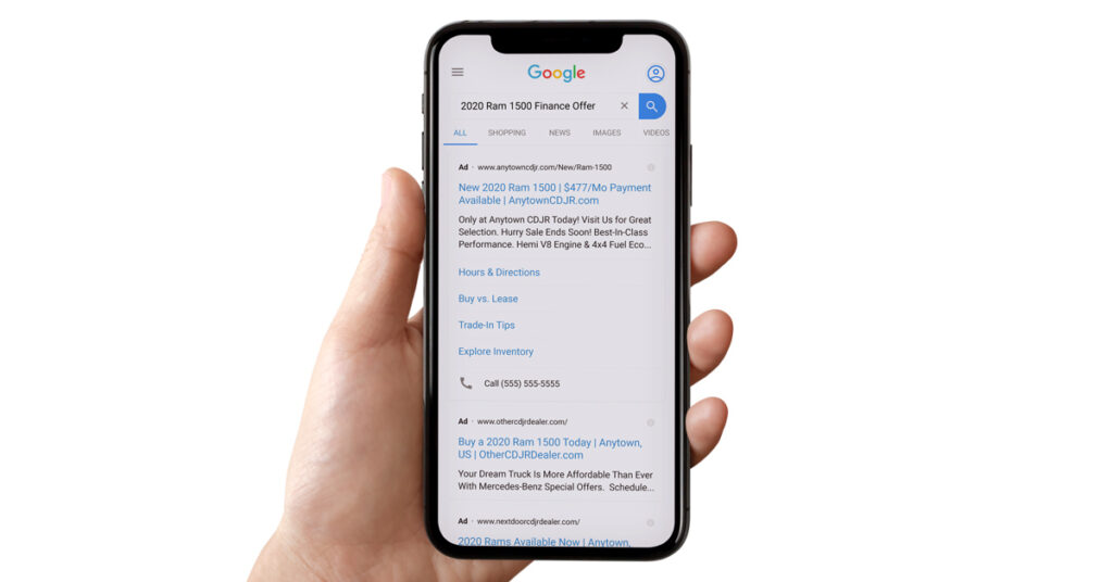 person holding mobile phone looking at a paid search ad on Google