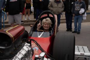 Lisa Hambelton, MHF in her race car holding up her finger in the No 1 